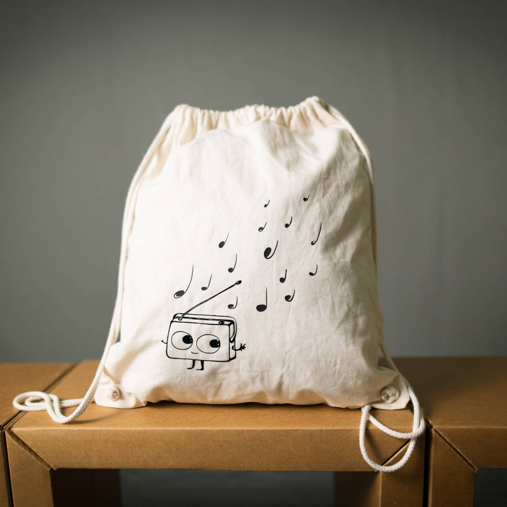 
                  
                    Musik Rucksack mit Radio Aufdruck, Turnbeutel Farbe natur beige, Motiv schwarz mit niedlichen tanzendem Radio und Musik Noten fürs Festival
                  
                