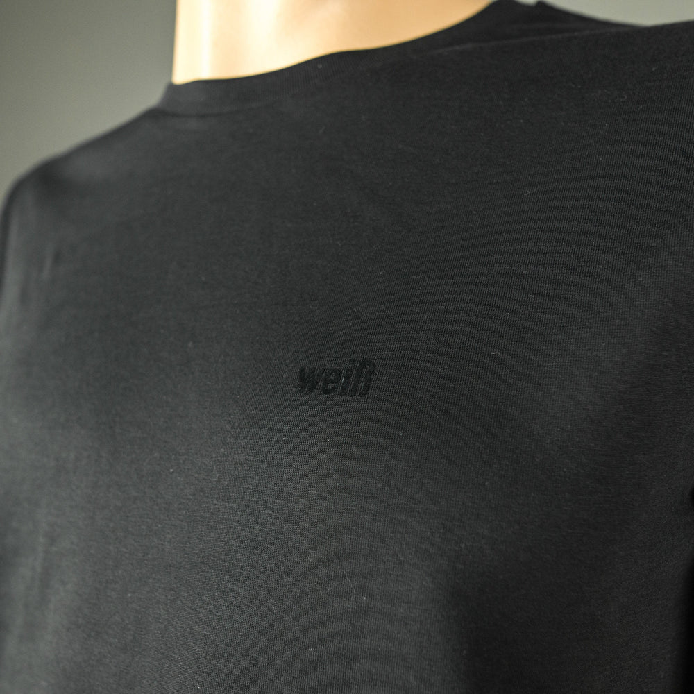 
                  
                    Weisses T-Shirt für Männer aus Biobaumwolle mit minimalistischem Brustlogo aus Flock schwarz
                  
                